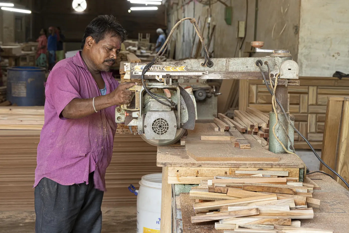 A craftsman cutting timber on a radial arm saw