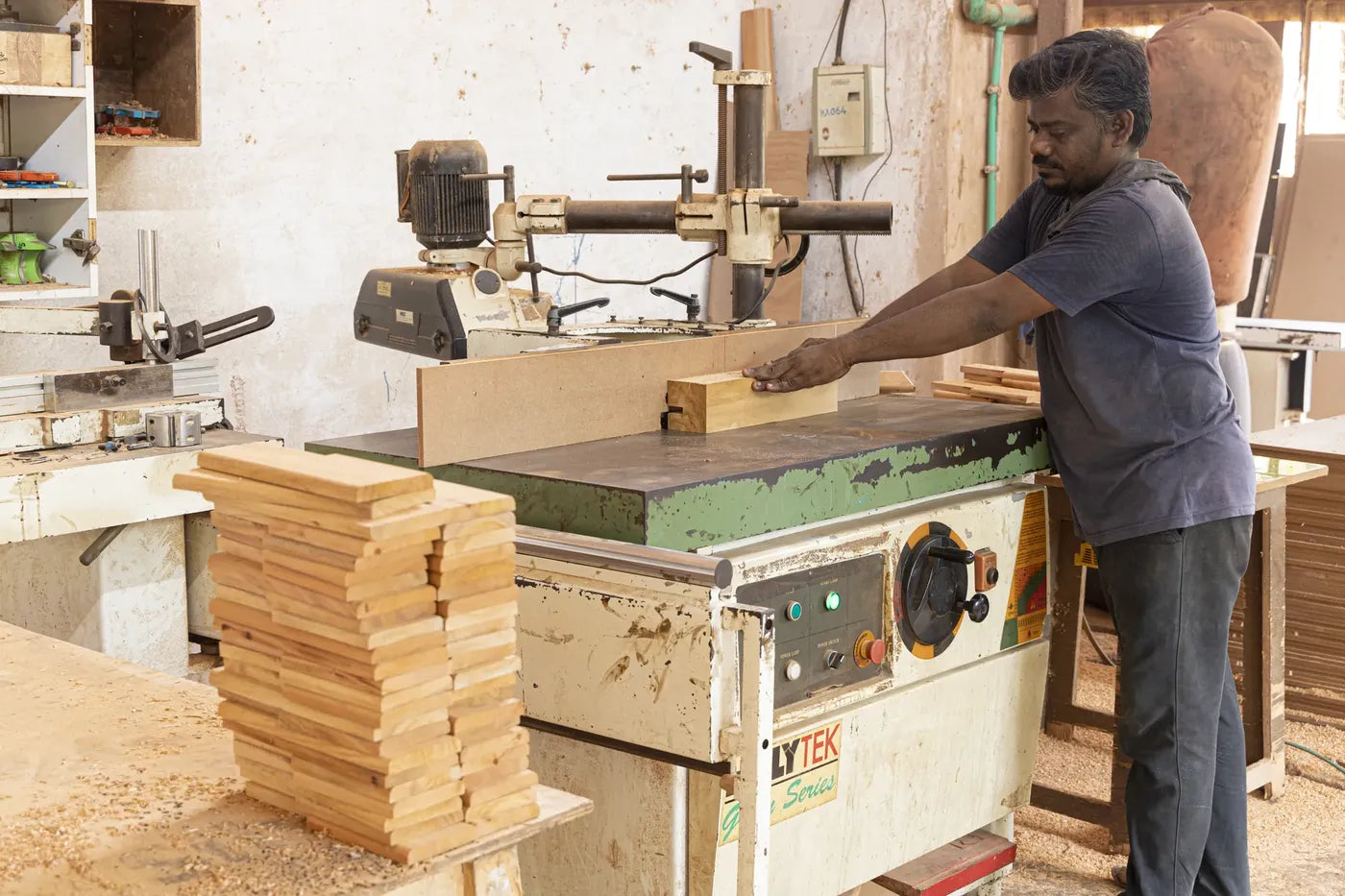 A craftsman shaping timber blocks on a spindle moulder in the Kalingaa workshop